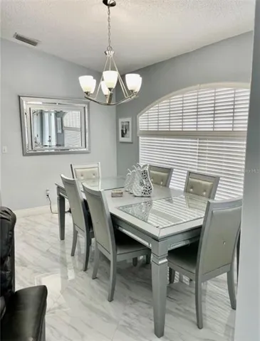 a view of a dining room with furniture a chandelier and wooden floor