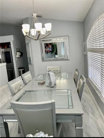 a view of a dining room with furniture and chandelier