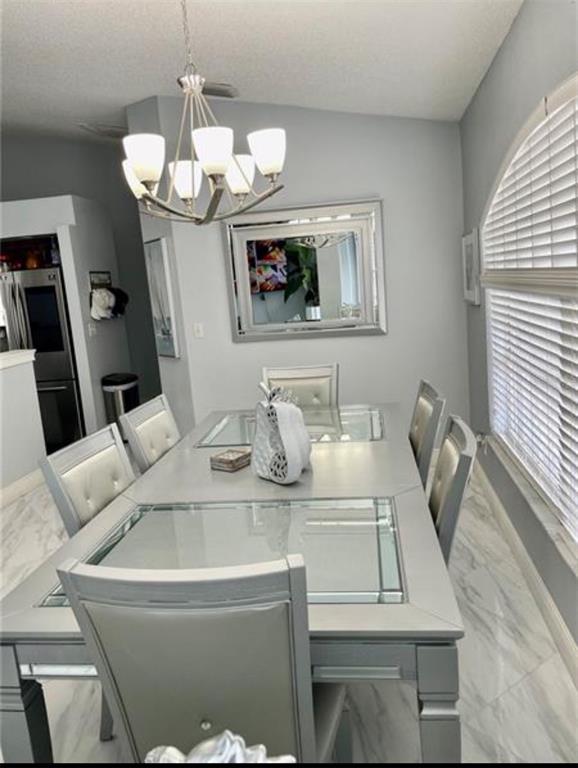 6125 Mariner Boulevard Spring Hill, FL 34608 - Photo 7 of 24 a view of a dining room with furniture and chandelier