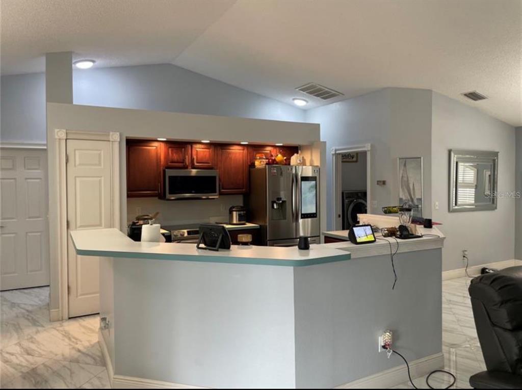 6125 Mariner Boulevard Spring Hill, FL 34608 - Photo 10 of 24 a room with stainless steel appliances a sink and a flat screen tv