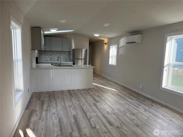 a kitchen with stainless steel appliances granite countertop a stove a sink and a large window