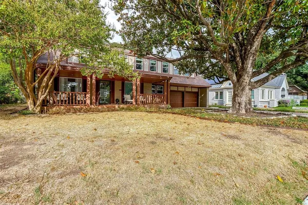 a front view of a house with a tree