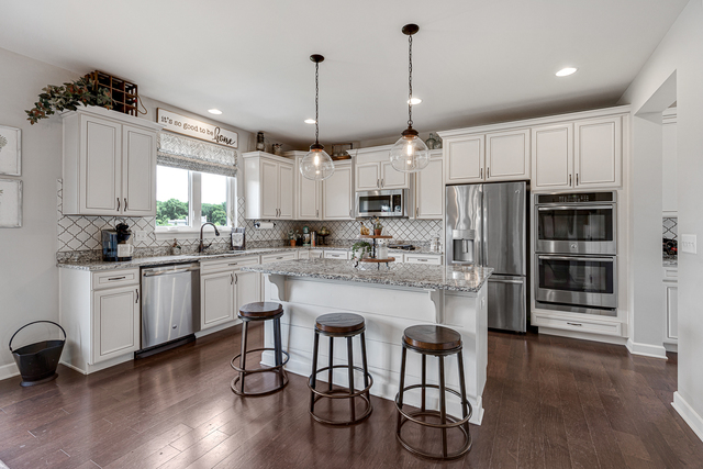 4380 John Milton Road Elgin, IL 60124 - Photo 6 of 30 a kitchen with stainless steel appliances kitchen island granite countertop a refrigerator a stove a sink dishwasher and white cabinets with wooden floor