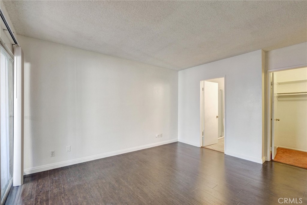 7033 Stewart And Gray Road, Unit 24 Downey, CA 90241 - Photo 18 of 39 a view of an empty room with wooden floor and a window