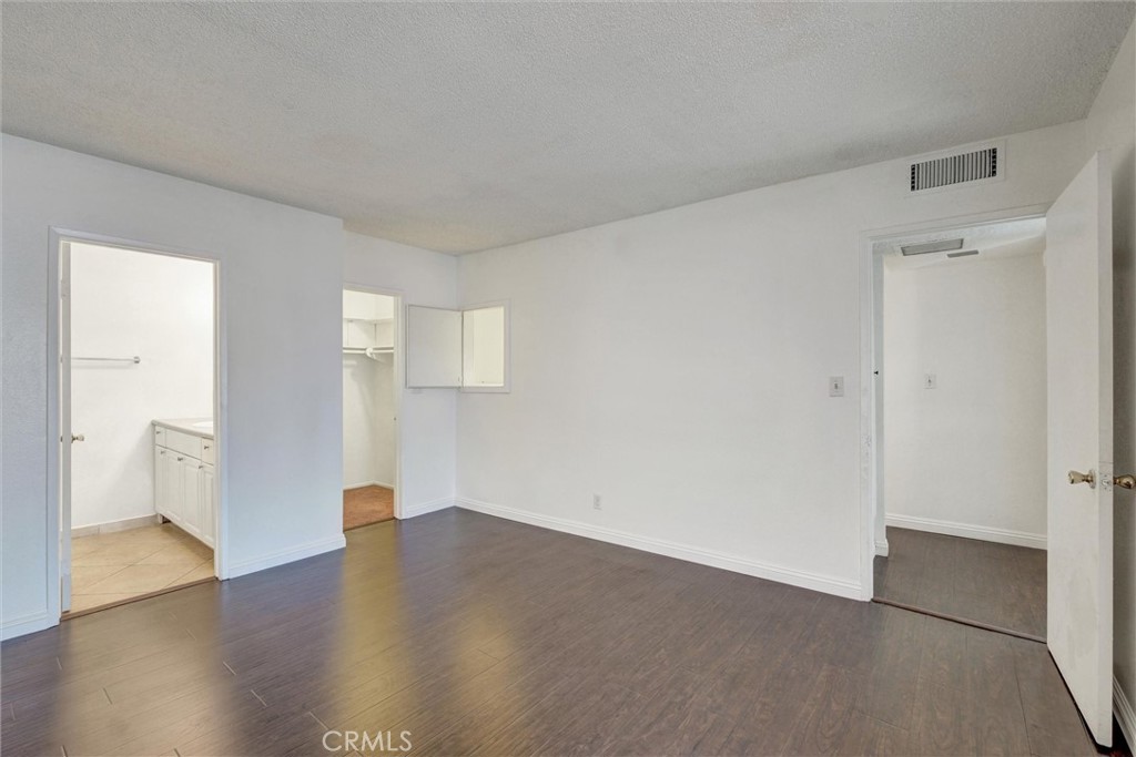 7033 Stewart And Gray Road, Unit 24 Downey, CA 90241 - Photo 19 of 39 a view of an empty room with wooden floor and a window
