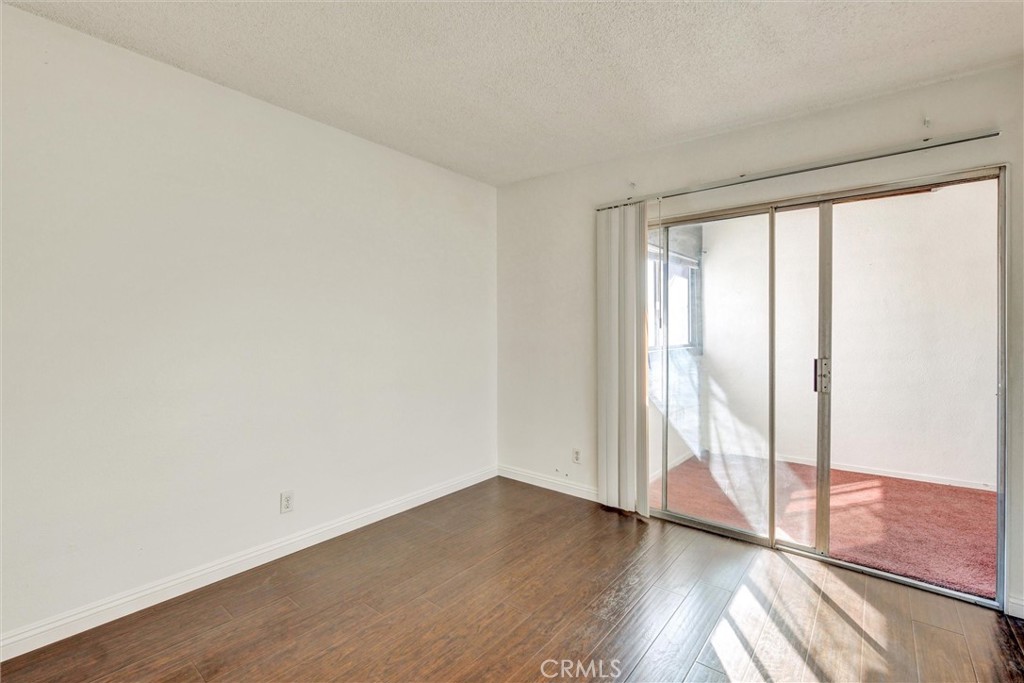 7033 Stewart And Gray Road, Unit 24 Downey, CA 90241 - Photo 22 of 39 an empty room with wooden floor and windows