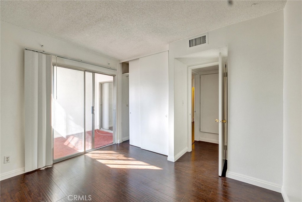 7033 Stewart And Gray Road, Unit 24 Downey, CA 90241 - Photo 23 of 39 wooden floor in an empty room with a window