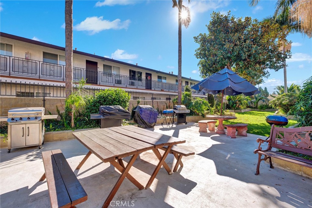 7033 Stewart And Gray Road, Unit 24 Downey, CA 90241 - Photo 35 of 39 a view of a patio with a table and chairs under an umbrella