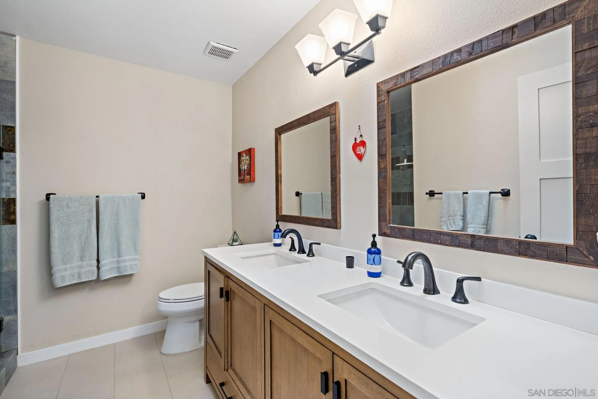 149 Beechtree Drive Encinitas, CA 92024 - Photo 26 of 55 a bathroom with a double vanity sink mirror and toilet
