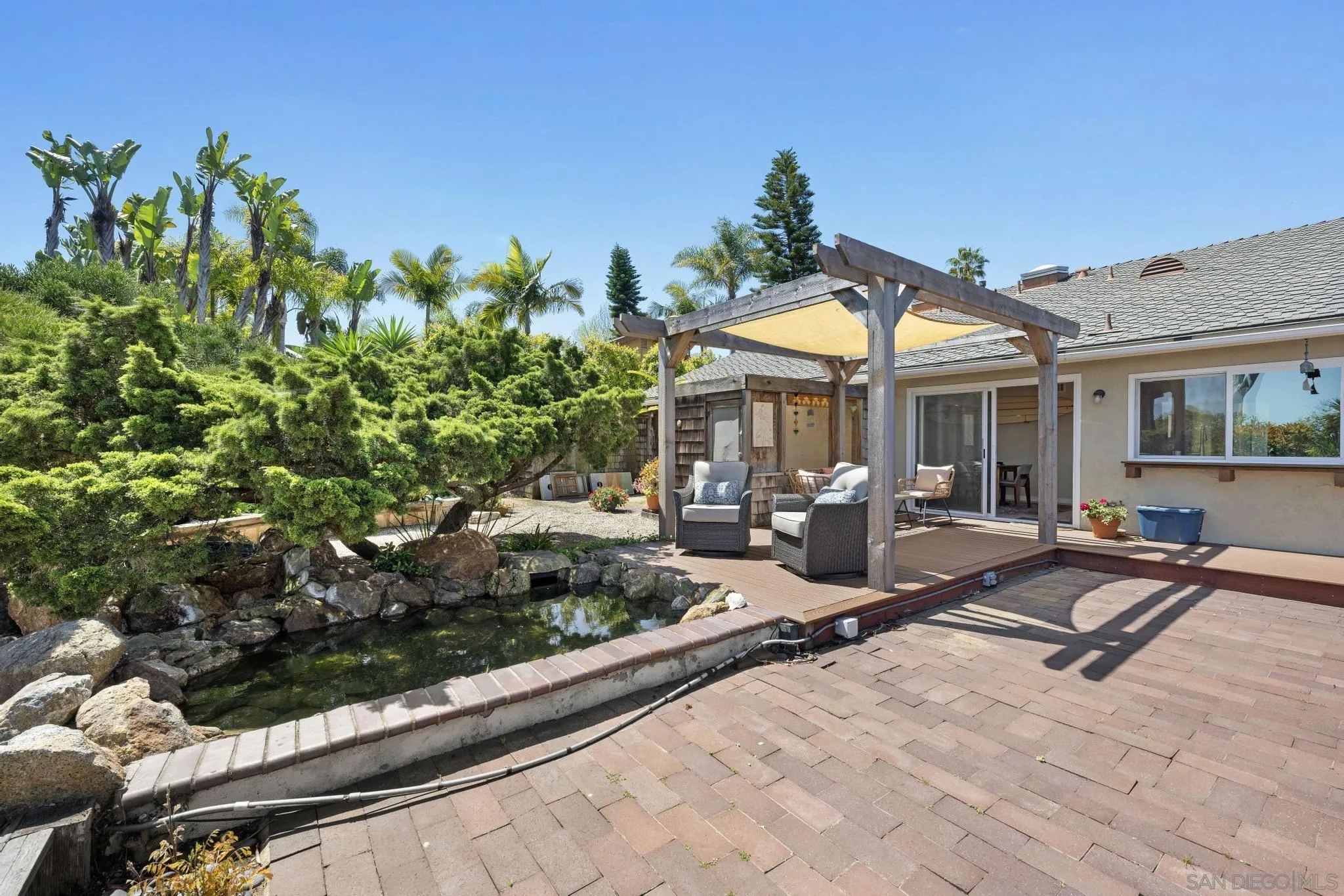 149 Beechtree Drive Encinitas, CA 92024 - Photo 30 of 55 a view of a patio with table and chairs under an umbrella