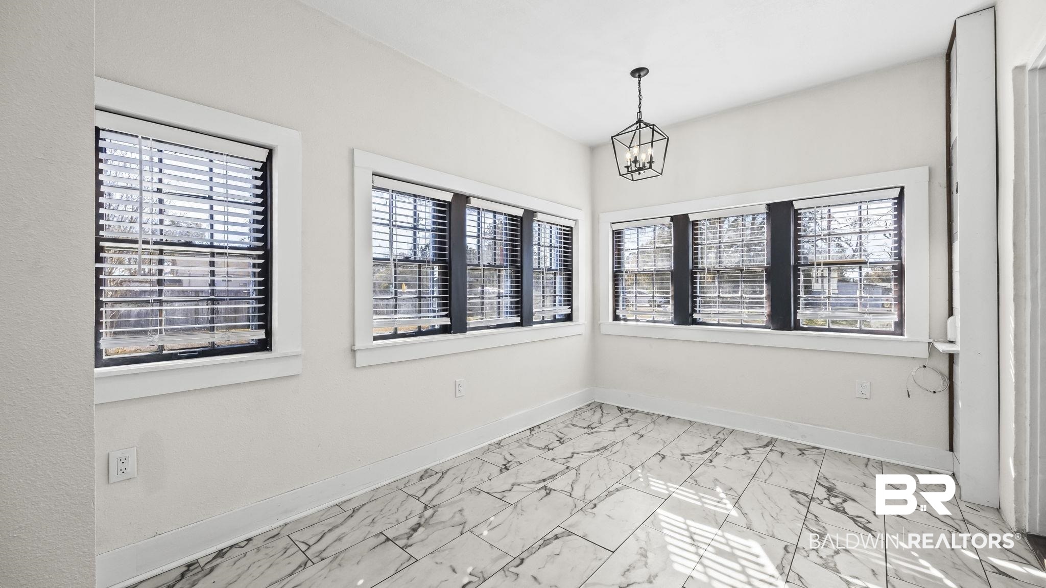 24701 Highway 98 Elberta, AL 36530 - Photo 13 of 32 Unfurnished room with light marble finish floors, plenty of natural light, and suspended lighting