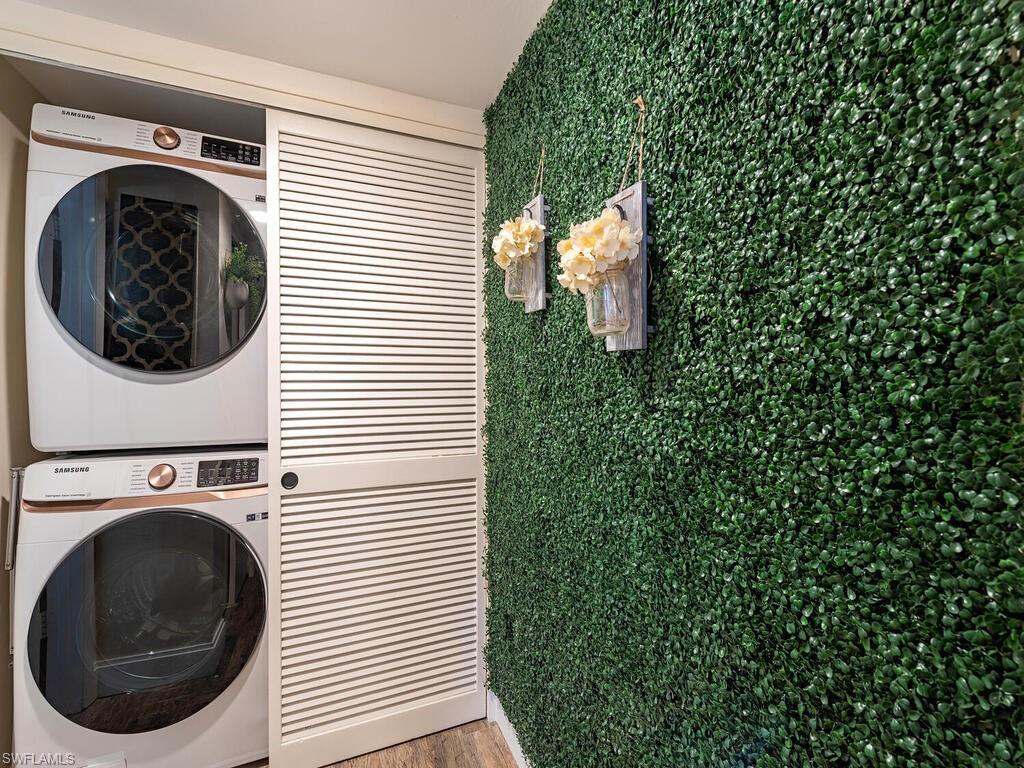 39 Watercolor Way, Unit 39 Naples, FL 34113 - Photo 12 of 12 Clothes washing area with stacked washer and clothes dryer, wood finished floors, and laundry area