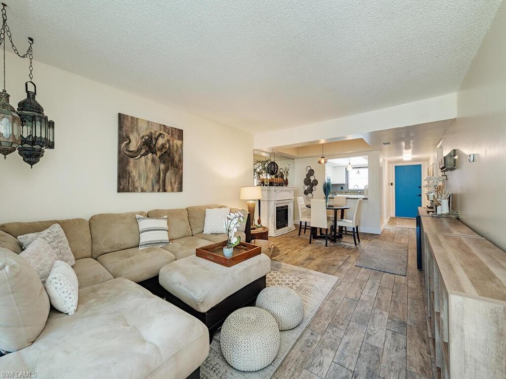 39 Watercolor Way, Unit 39 Naples, FL 34113 - Photo 3 of 12 Living room featuring a textured ceiling and wood finished floors