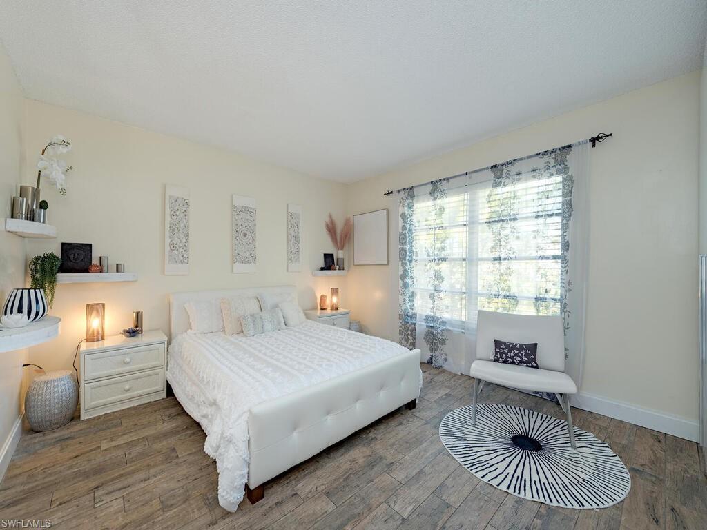 39 Watercolor Way, Unit 39 Naples, FL 34113 - Photo 6 of 12 Bedroom with baseboards and wood finished floors