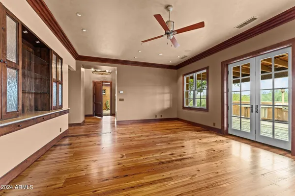 a view of empty room with wooden floor and fan