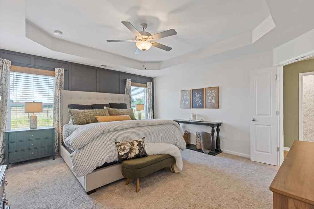 60 Huntley Trace Hoschton, GA 30548 - Photo 25 of 50 a bedroom with a bed and a chandelier