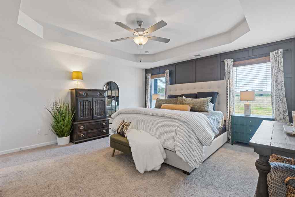 60 Huntley Trace Hoschton, GA 30548 - Photo 26 of 50 a bedroom with a bed a couch and a potted plant on the dresser