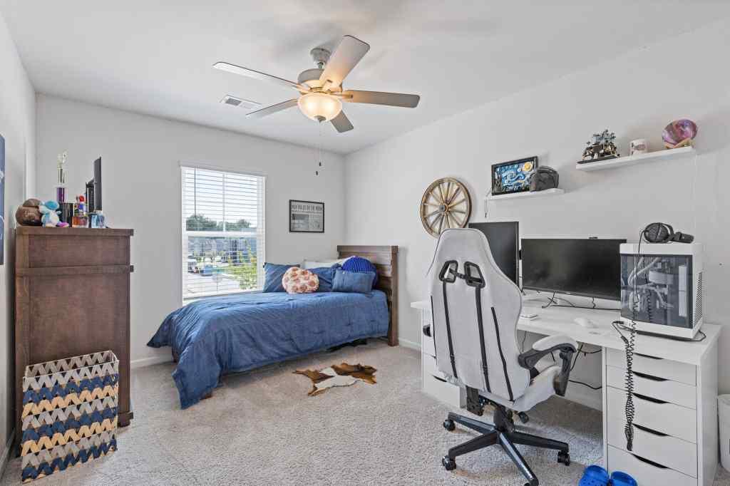 60 Huntley Trace Hoschton, GA 30548 - Photo 34 of 50 a bedroom with a bed and a chandelier