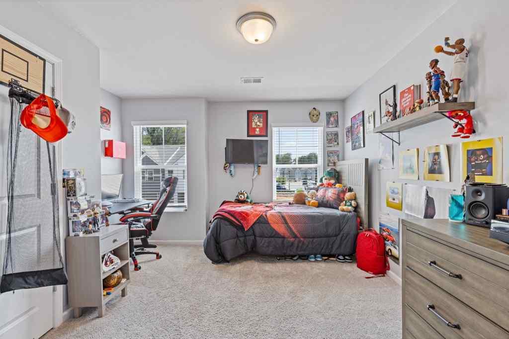 60 Huntley Trace Hoschton, GA 30548 - Photo 35 of 50 a bedroom with bed and a chandelier