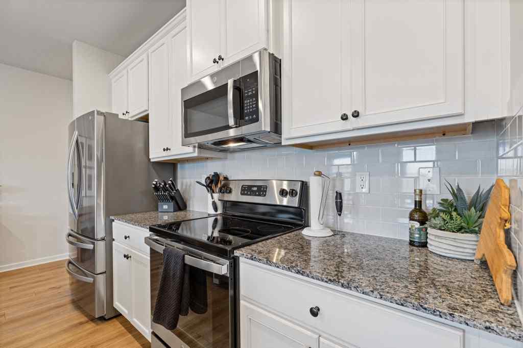 60 Huntley Trace Hoschton, GA 30548 - Photo 9 of 50 a kitchen with stainless steel appliances granite countertop a stove a microwave and a refrigerator