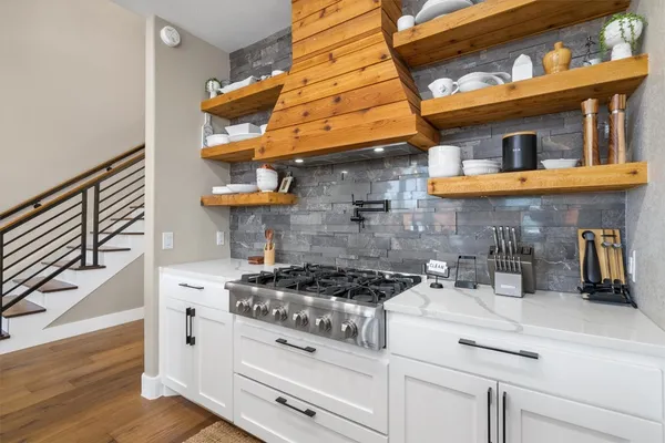 a kitchen with stainless steel appliances granite countertop a stove and cabinets