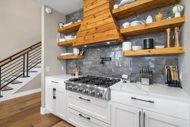 a kitchen with stainless steel appliances granite countertop a stove and cabinets