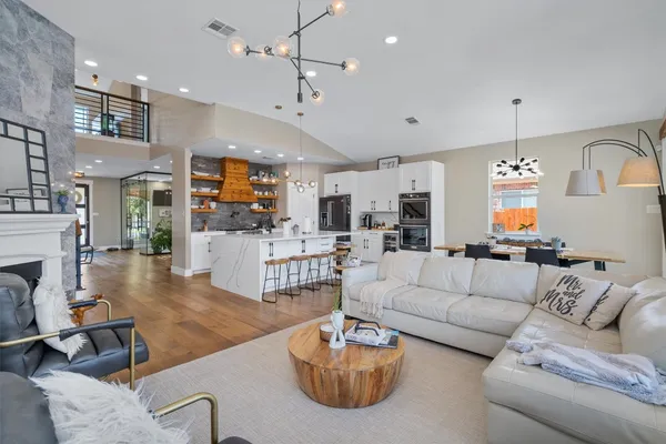 a living room with furniture a fireplace and a chandelier