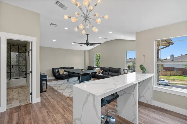 a view of a dining room with furniture a chandelier and wooden floor