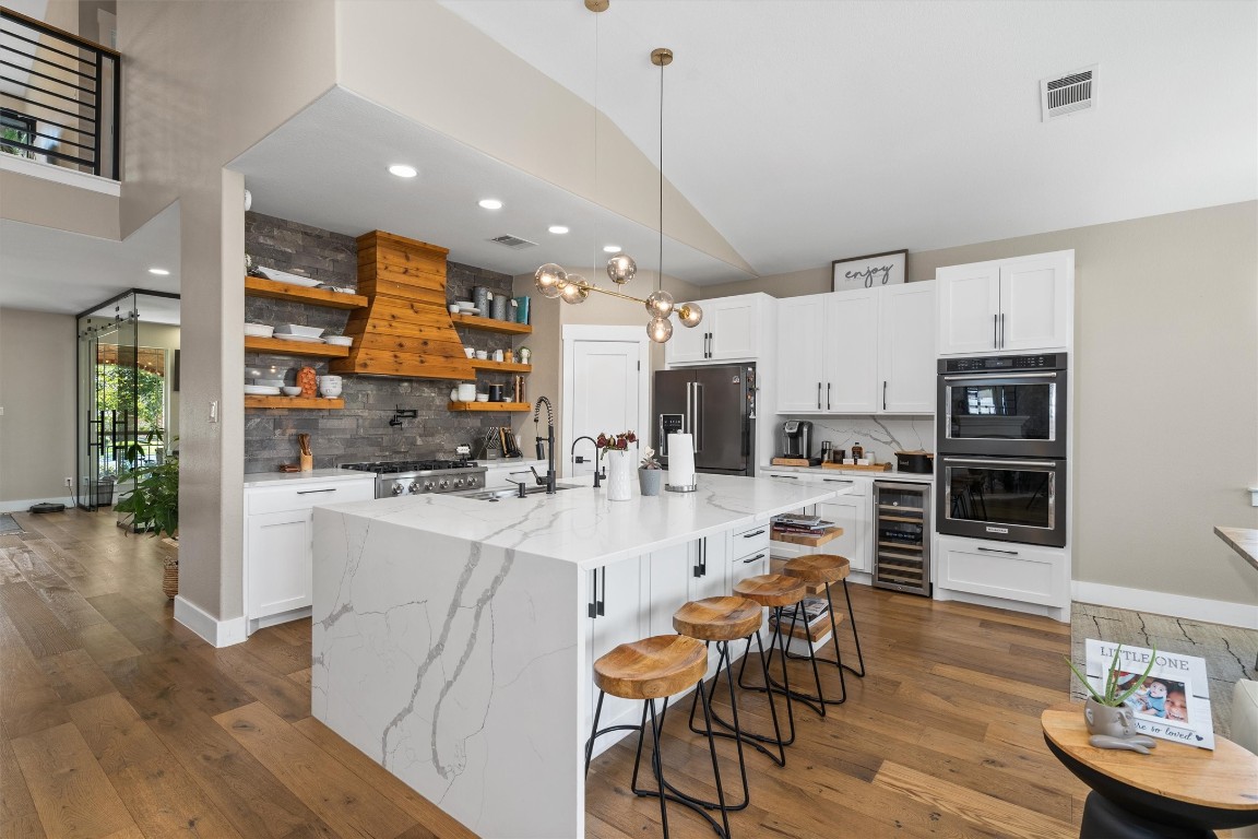 542 Centerbrook Place Round Rock, TX 78665 - Photo 9 of 40 a kitchen with stainless steel appliances kitchen island granite countertop a table chairs and a refrigerator