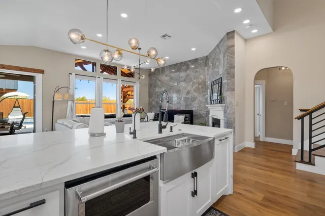 a large kitchen with stainless steel appliances a large counter top a stove and a sink