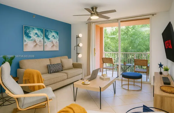 a living room with furniture a flat screen tv and a large window