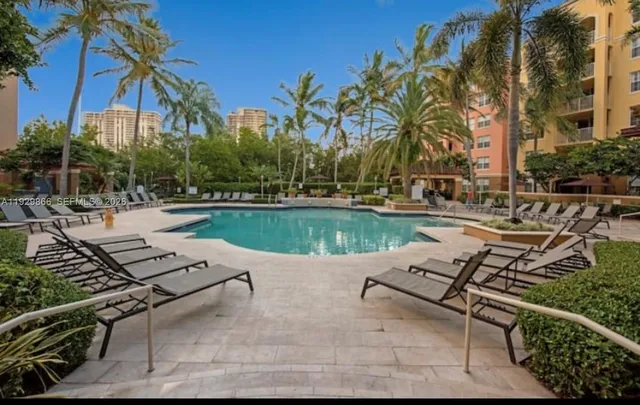 a view of a swimming pool with lounge chairs in patio