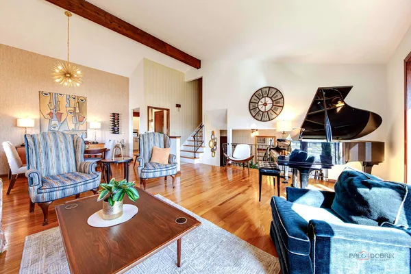 a living room with furniture kitchen view and a large window