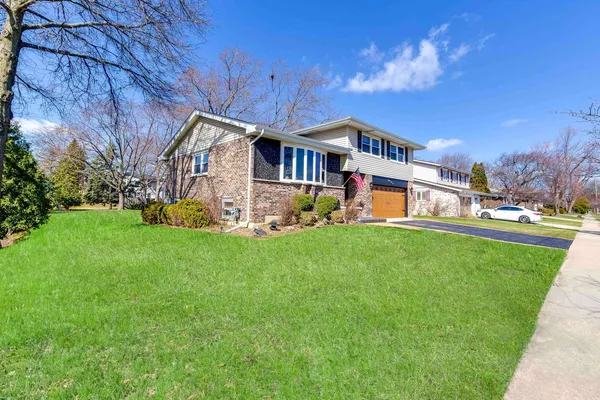 a front view of a house with a garden and yard