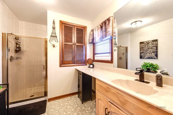 a bathroom with a granite countertop sink mirror and shower