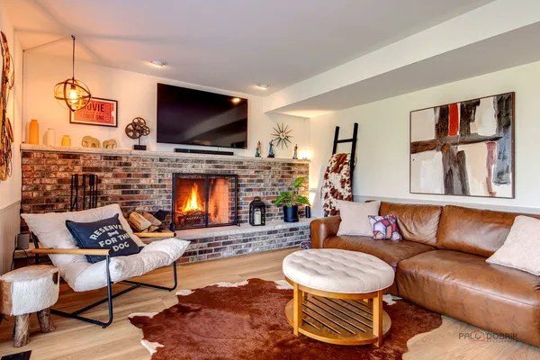 a living room with furniture a flat screen tv and a fireplace