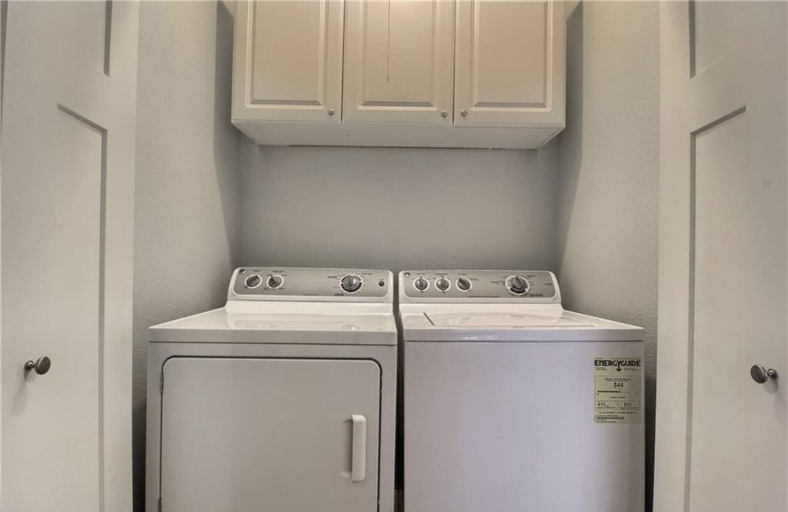 702 West N Loop Boulevard Austin, TX 78751 - Photo 23 of 23 Functional utility space with convenient upper cabinetry and essential laundry appliances.