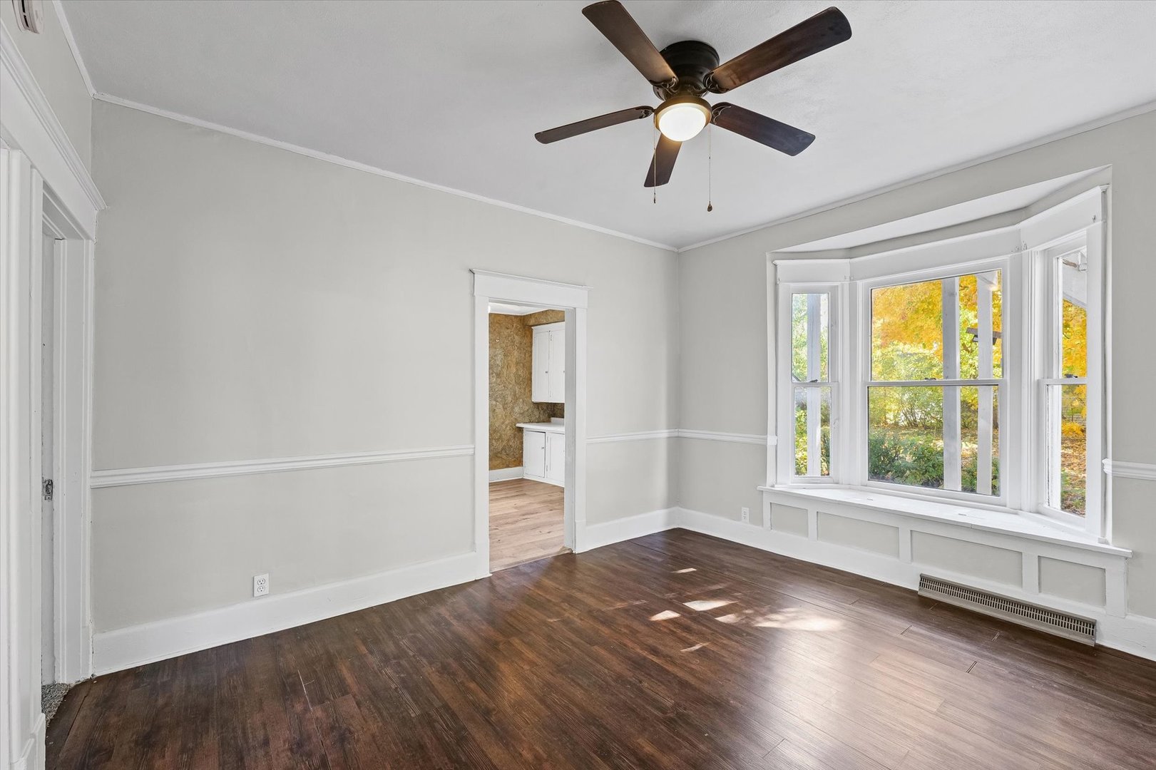 208 South Poplar Street Urbana, IL 61802 - Photo 7 of 30 an empty room with wooden floor chandelier fan and windows
