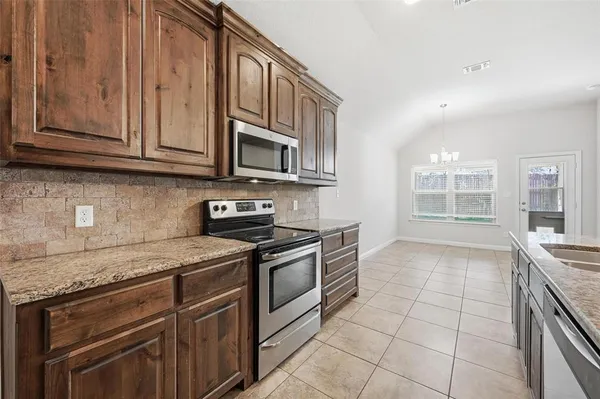 a kitchen with stainless steel appliances granite countertop a sink and a stove