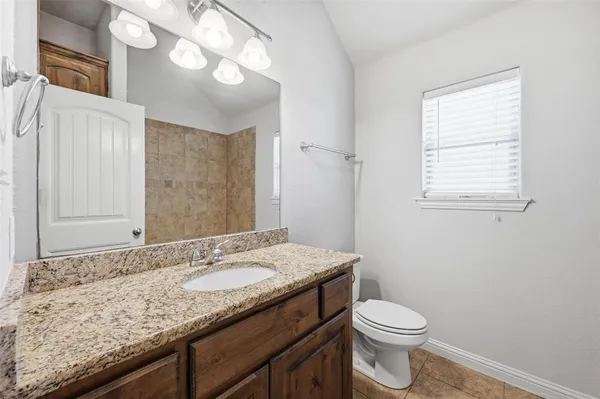 a bathroom with a granite countertop sink a mirror and a shower