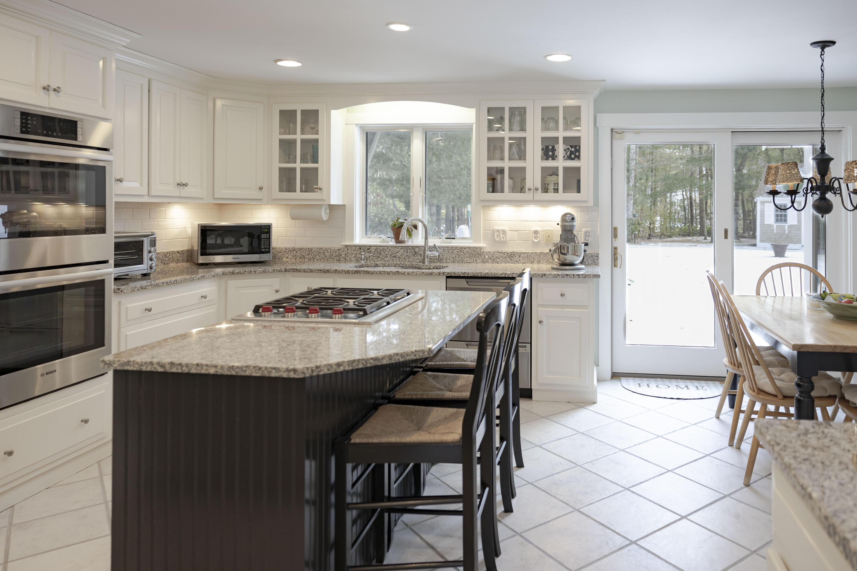 98 Bunker Hill Road Osterville, MA 02655 - Photo 16 of 88 a kitchen with stainless steel appliances granite countertop a stove a sink a microwave a dining table and chairs