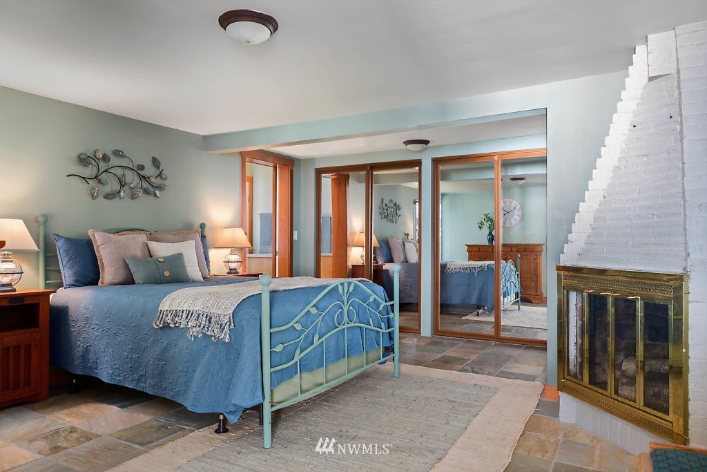 5036 Scurlock Road Freeland, WA 98249 - Photo 11 of 25 a bedroom with a bed and a fireplace