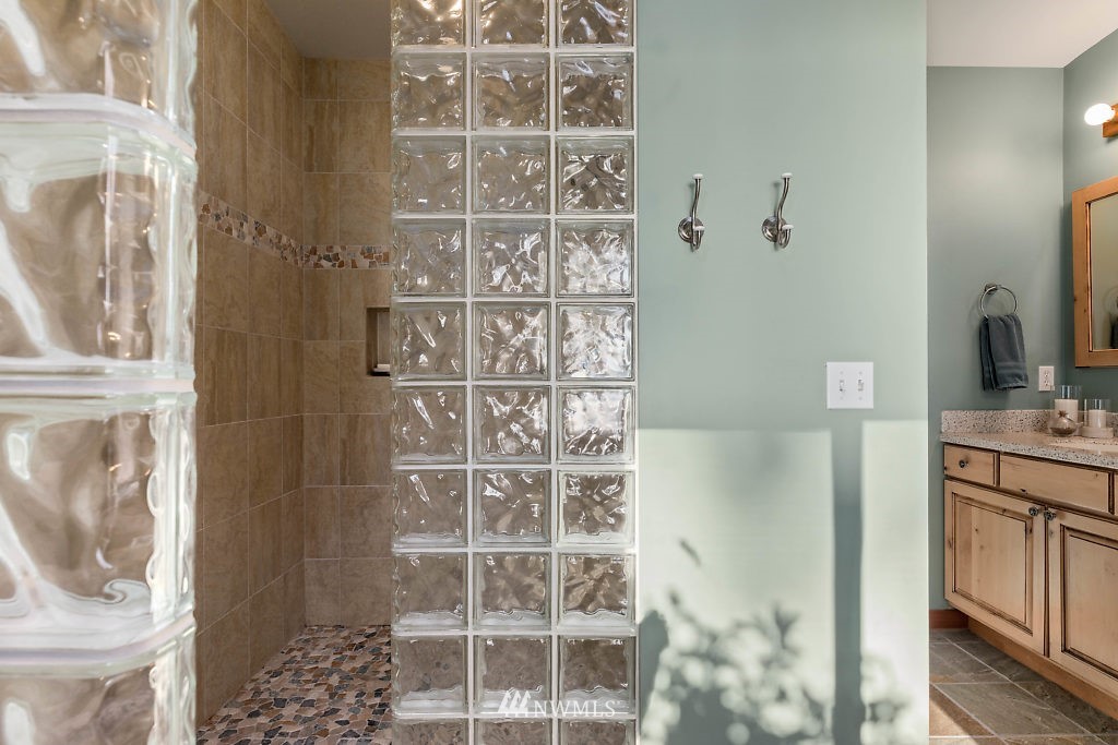 5036 Scurlock Road Freeland, WA 98249 - Photo 14 of 25 a bathroom with a granite countertop shower a mirror and a sink