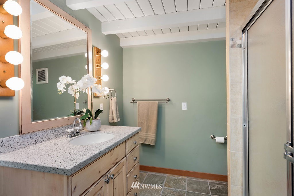 5036 Scurlock Road Freeland, WA 98249 - Photo 16 of 25 a bathroom with a granite countertop sink a mirror and a shower