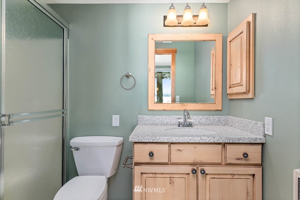 5036 Scurlock Road Freeland, WA 98249 - Photo 20 of 25 a bathroom with a granite countertop toilet sink and mirror