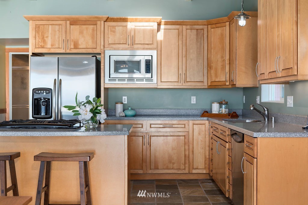 5036 Scurlock Road Freeland, WA 98249 - Photo 6 of 25 a kitchen with stainless steel appliances granite countertop a sink a stove and cabinets