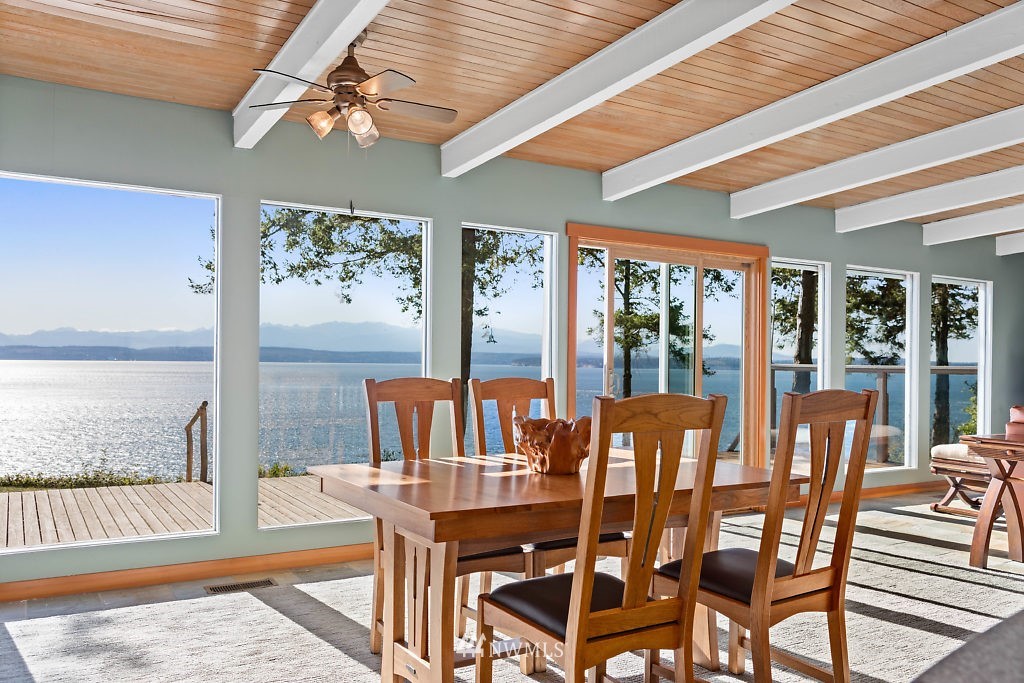 5036 Scurlock Road Freeland, WA 98249 - Photo 8 of 25 a view of a dining room with furniture large windows and wooden floor
