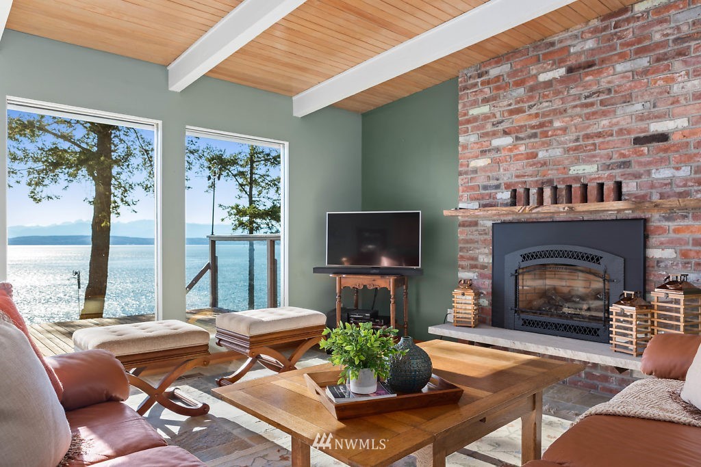 5036 Scurlock Road Freeland, WA 98249 - Photo 10 of 25 a living room with furniture a flat screen tv and a fireplace