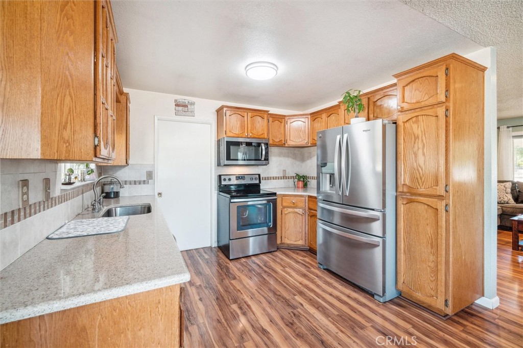 6791 Whispering Canyon Drive Anderson, CA 96007 - Photo 12 of 51 a kitchen with granite countertop stainless steel appliances a refrigerator a stove a sink and cabinets