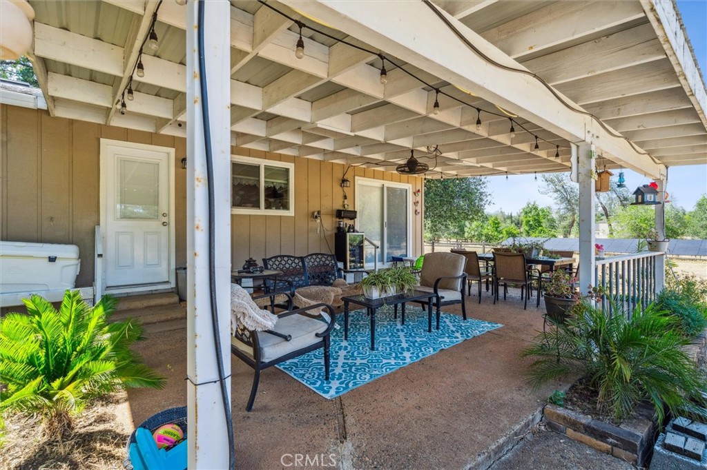 6791 Whispering Canyon Drive Anderson, CA 96007 - Photo 23 of 51 a view of a patio with table and chairs potted plants and floor to ceiling window